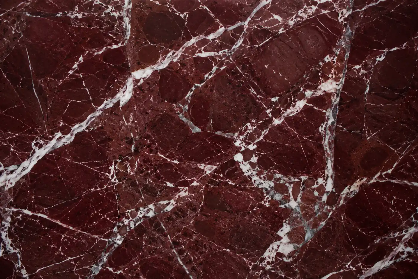 Rosso Levanto marble with white veining on a deep burgundy surface